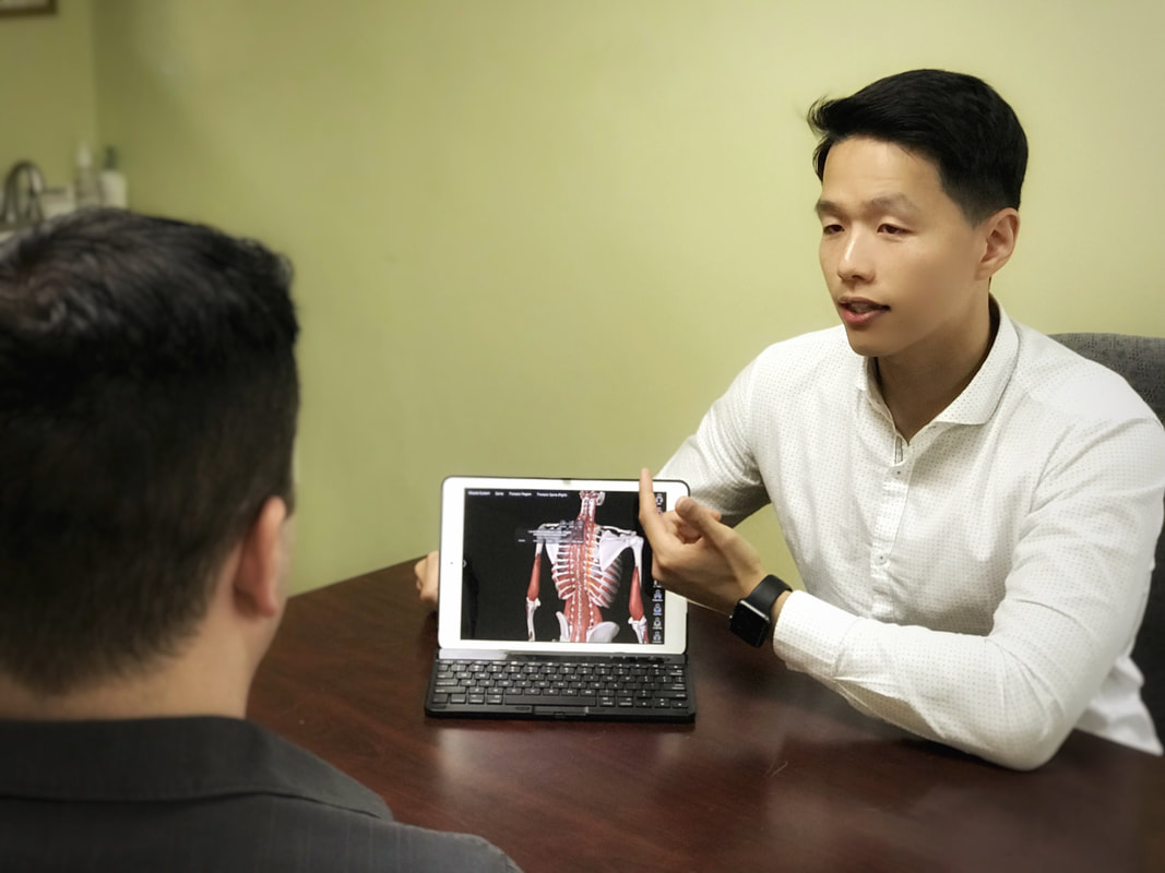 Brandon Lim explaining shoulder anatomy and a personalized treatment plan during a one-on-one appointment